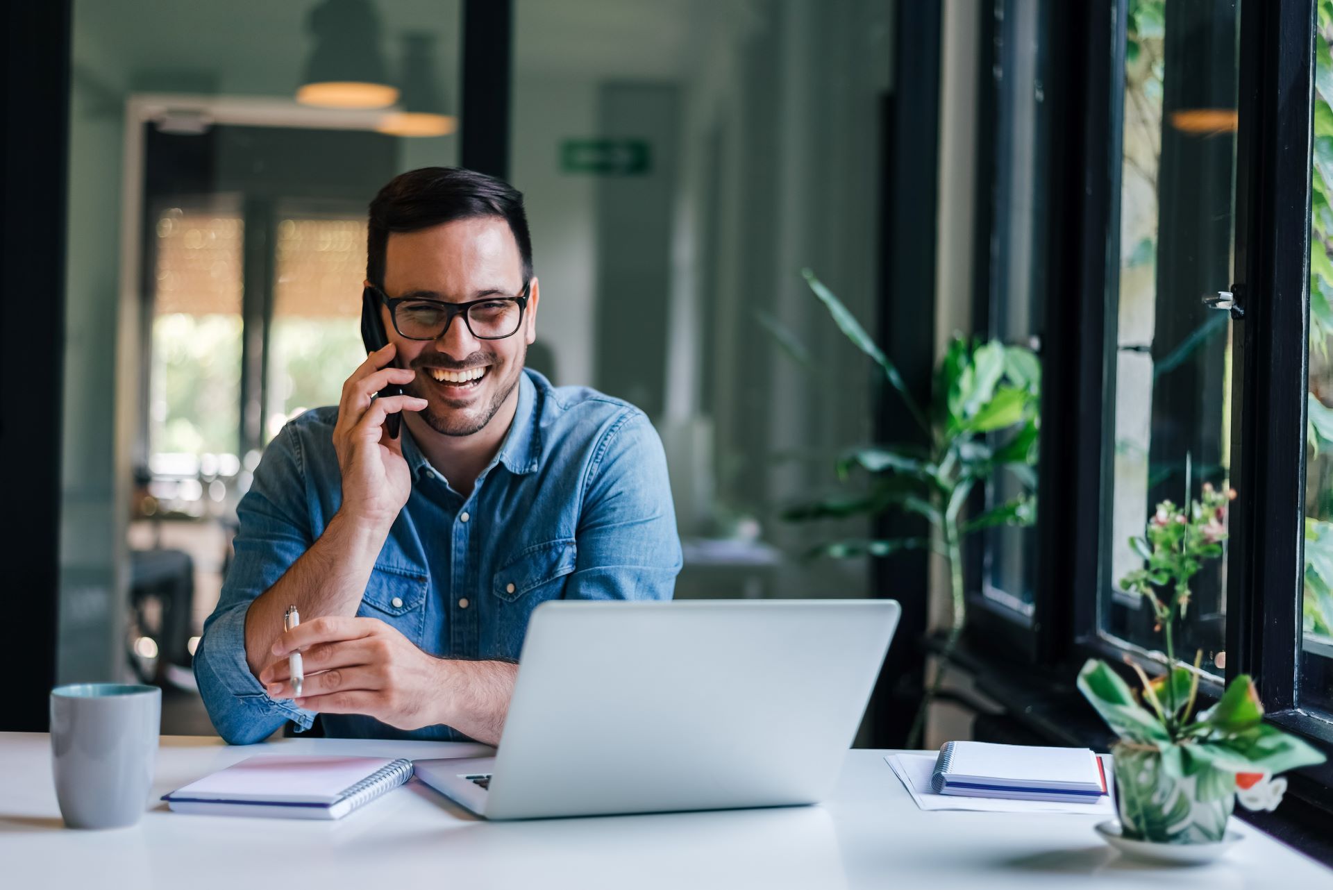 A man speaks on the phone in a professional setting, representing the discovery call that begins every consulting engagement with Arpco Legacy.