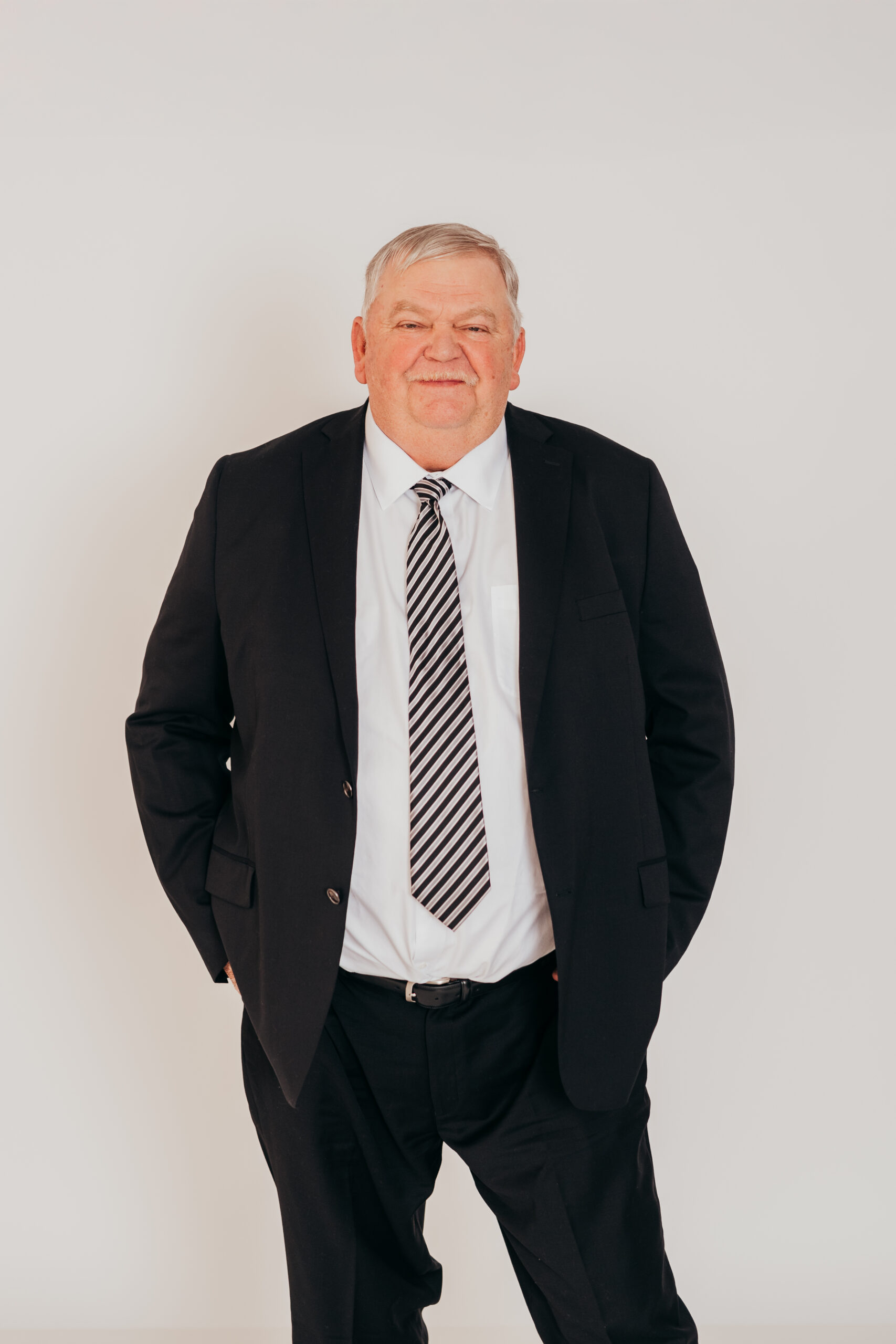 Portrait of Gary Tuner, co-founder of Arpco Legacy Enterprises, wearing a black suit and striped tie — representing leadership and operational expertise.